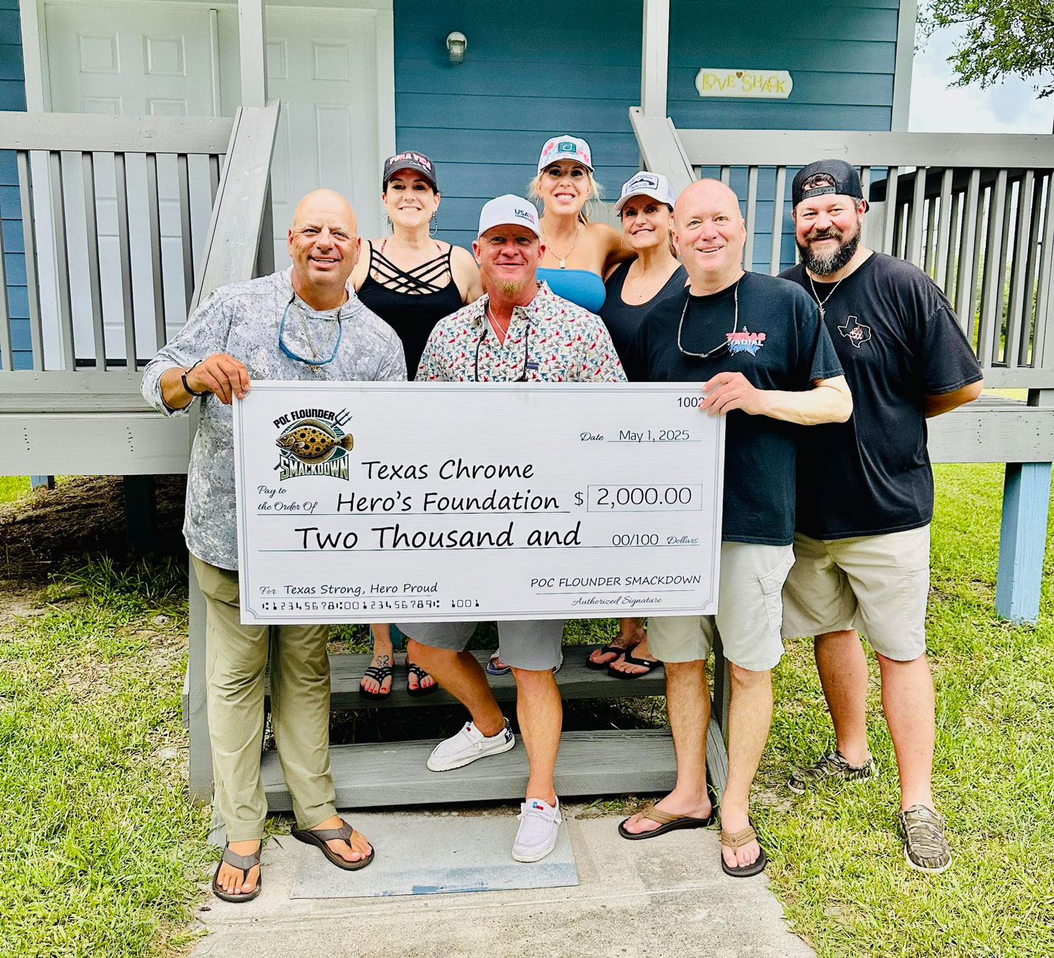 A group of seven people stand outside holding a large $2,000 check for the Texas Chrome Hero’s Foundation.